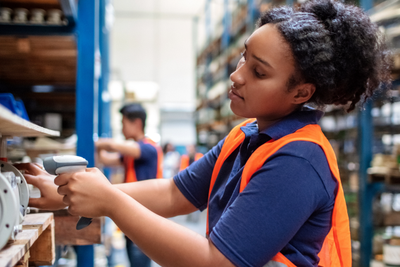 Female scanning a product with a barcode scanner in a warehouse Female scanning a product with a barcode scanner in a warehouse