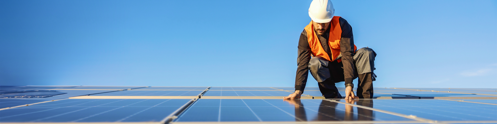 Man with hardhat on solar panels Man with hardhat on solar panels