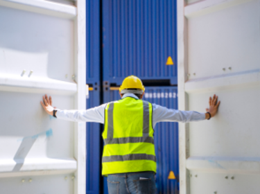 Worker opening shipping container doors Worker opening shipping container doors