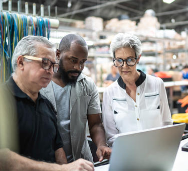 Three people looking at a laptop Three people looking at a laptop